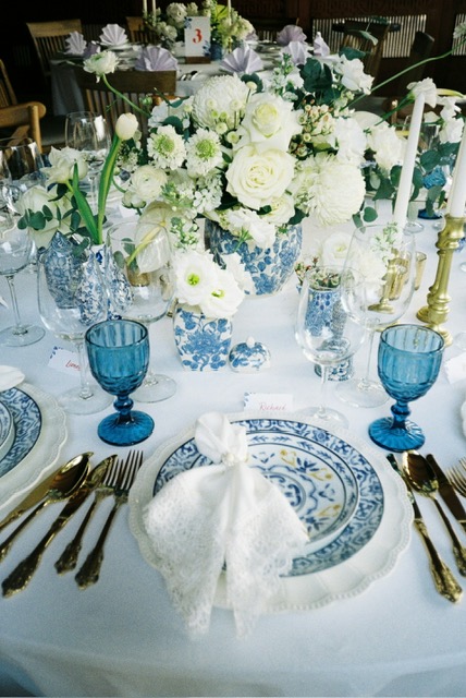 Blue floral and candle arrangement on a styled event table